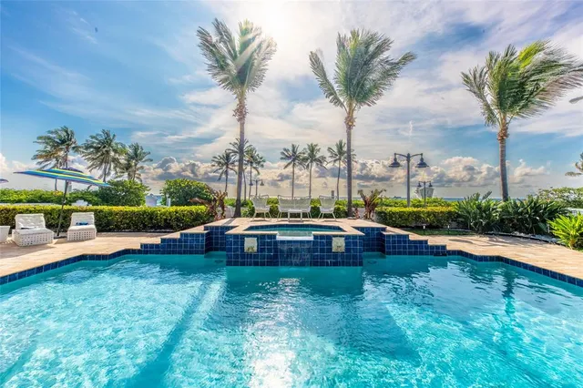 a view of yard with swimming pool and tall trees