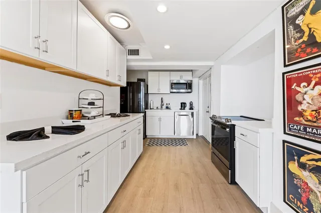 a kitchen with cabinets and wooden floor