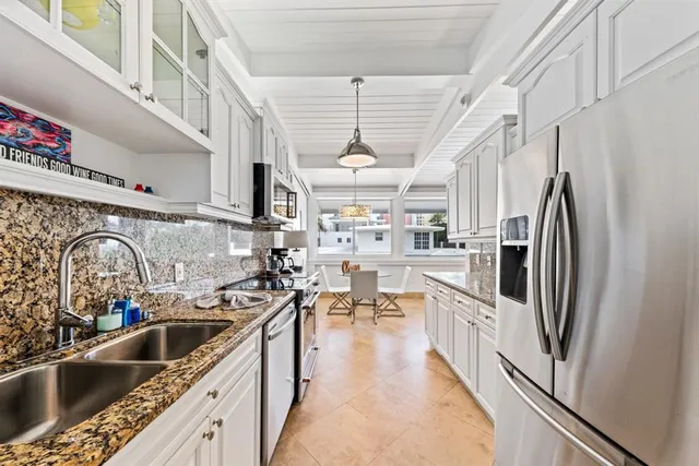 a kitchen with stainless steel appliances granite countertop a sink a stove and a refrigerator