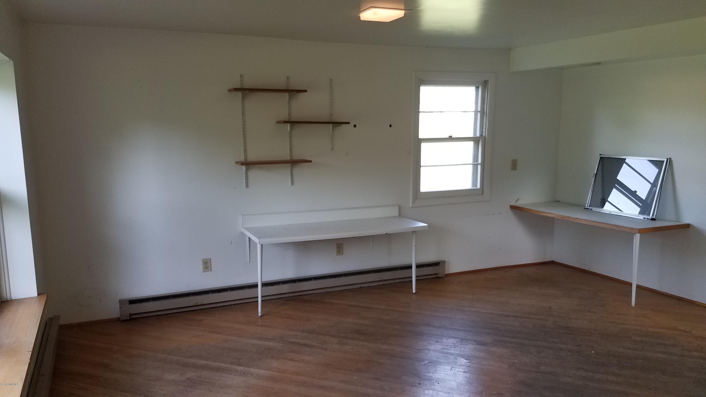429 Hancock Road Williamstown, MA 01267 - Photo 23 of 33 a view of an empty room with wooden floor and a window