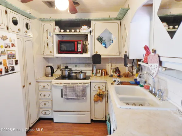 a kitchen with a stove a sink and a refrigerator