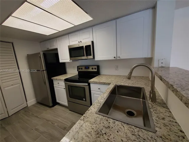 a kitchen with a sink stove and refrigerator