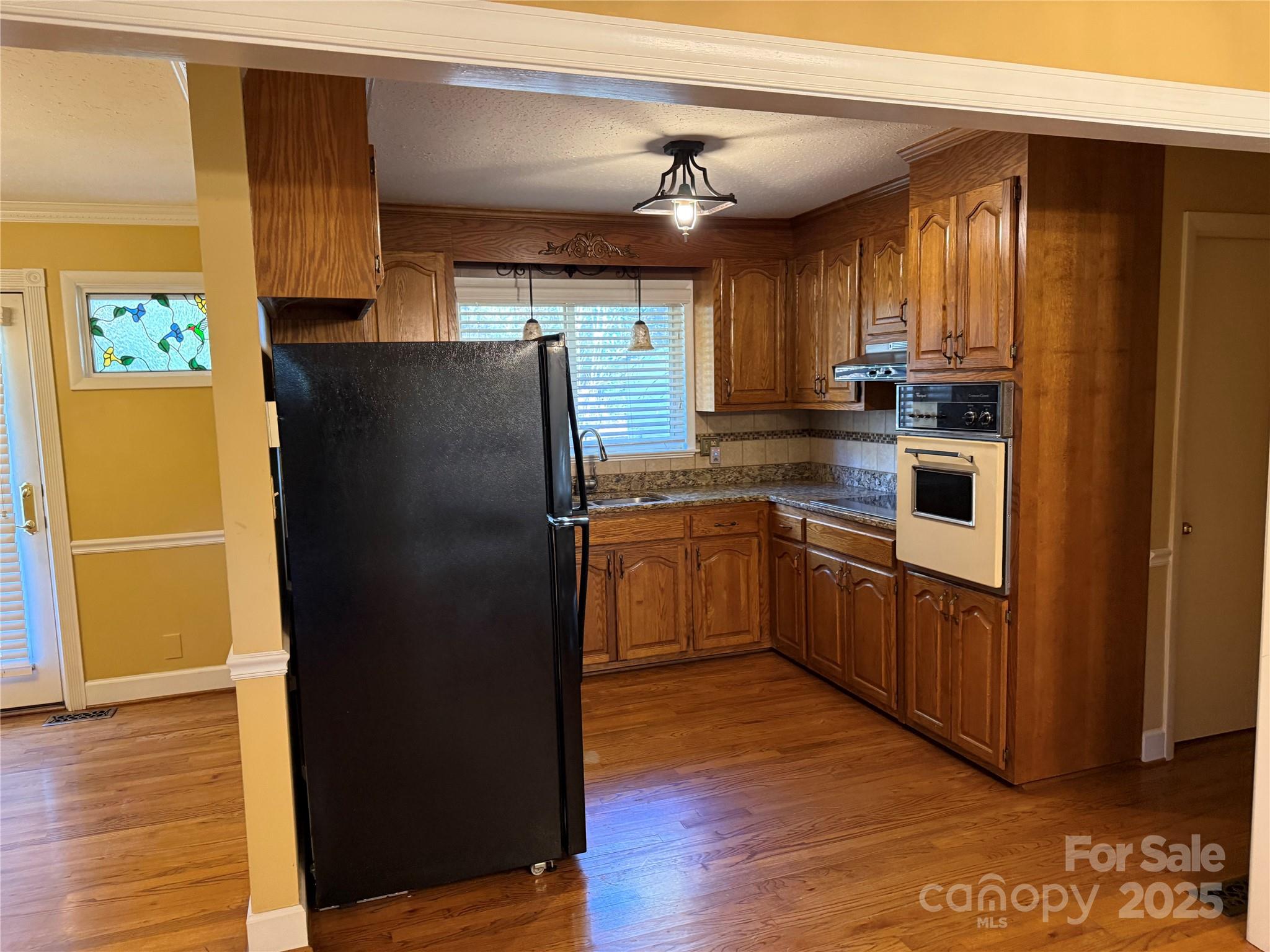 110 Forest Drive Locust, NC 28097 - Photo 11 of 29 a kitchen with a refrigerator sink and wooden floor