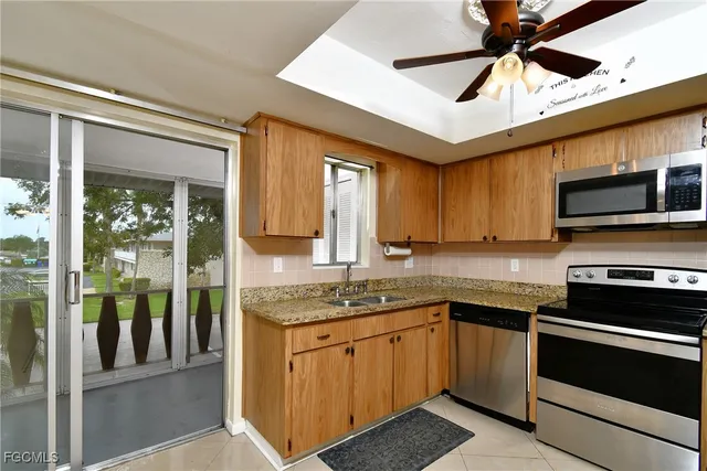 a kitchen with stainless steel appliances granite countertop a sink stove microwave and refrigerator