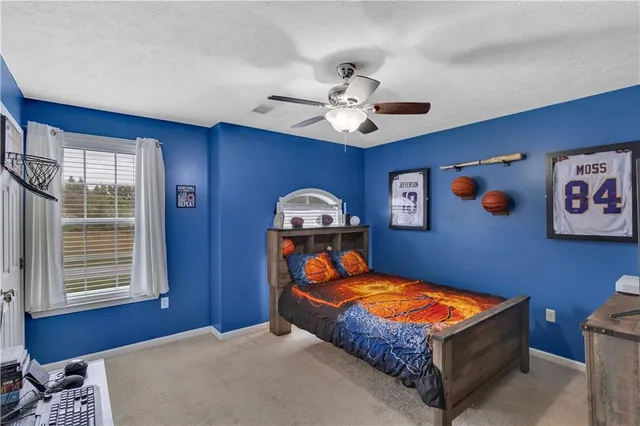 a bedroom with a large bed chandelier and a window