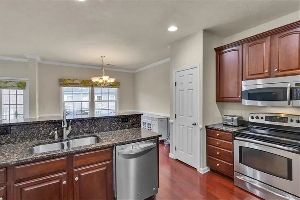 a kitchen with stainless steel appliances granite countertop a sink stove and refrigerator