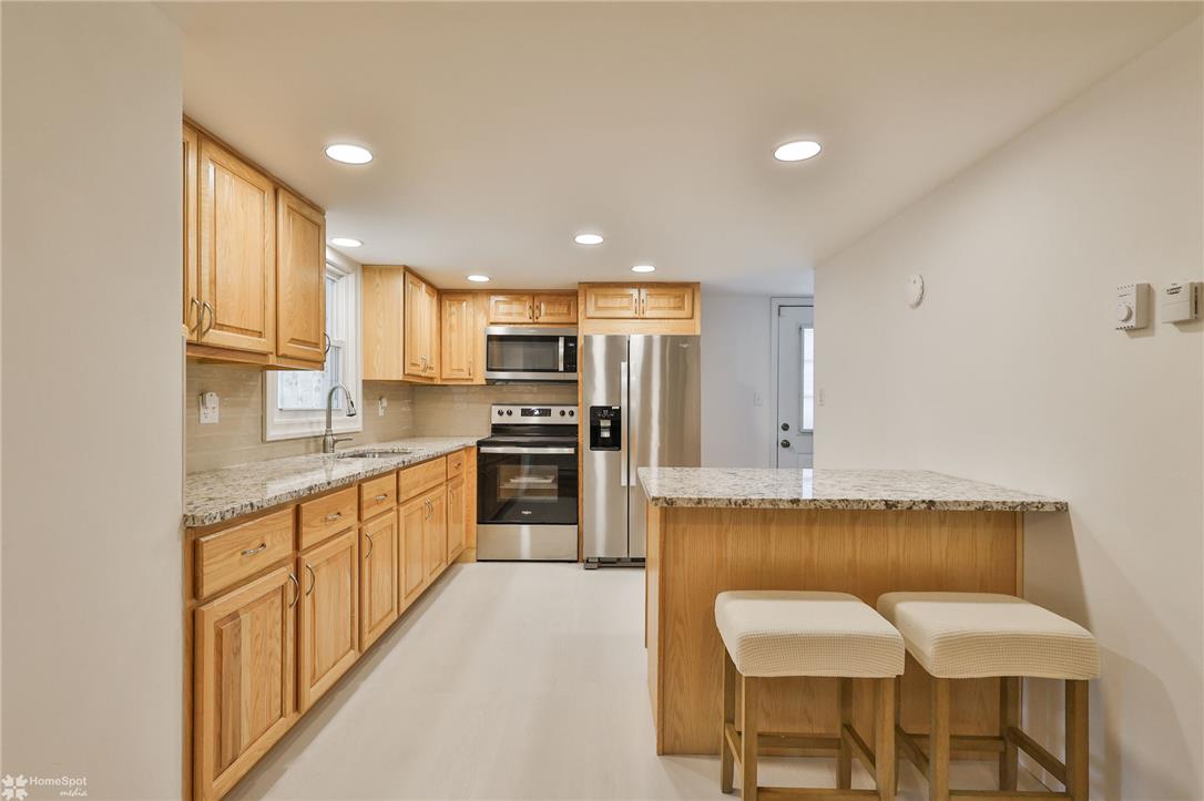 205 West Moorestown Road Wind Gap, PA 18091 - Photo 4 of 20 A well-appointed kitchen features natural wood cabinetry and a functional island with bar seating.