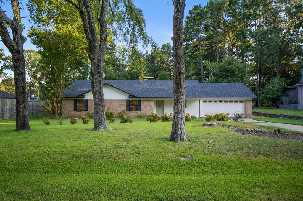 a view of a house with a big yard and large trees