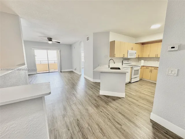a living room with stainless steel appliances kitchen island granite countertop wooden floor and view living room