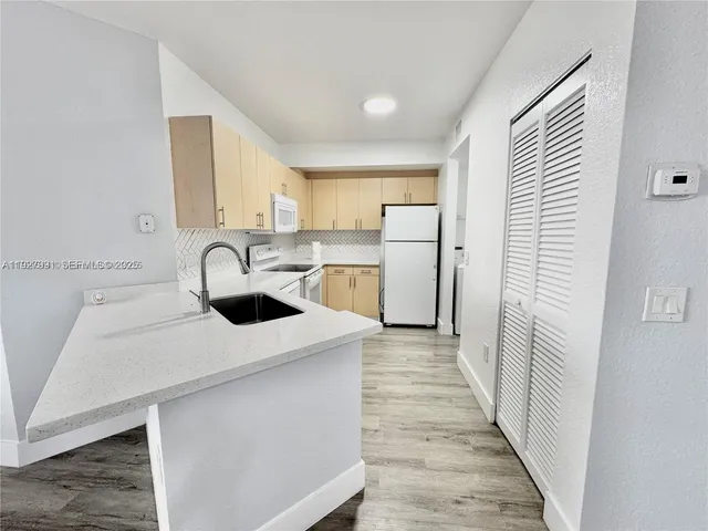 a kitchen with a sink a refrigerator and a stove