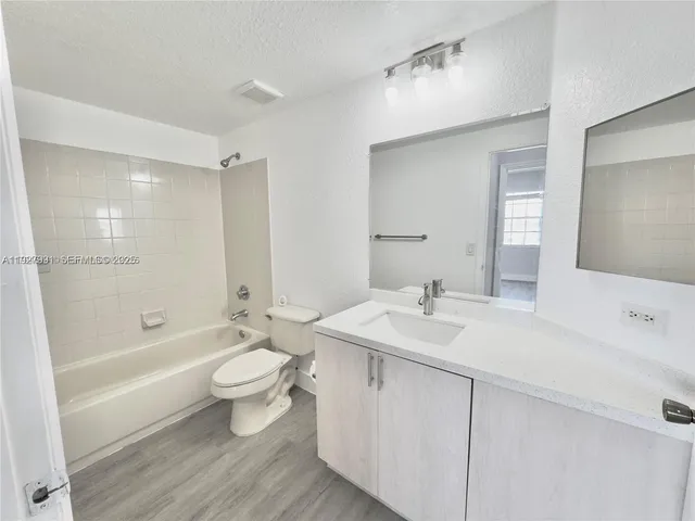 a bathroom with a sink a toilet and a large mirror