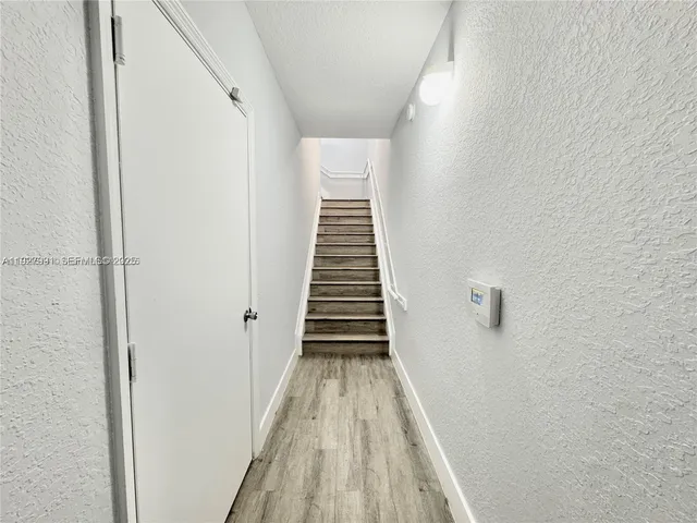 a view of a hallway with wooden floor and entryway
