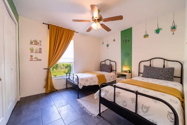 a bedroom with 2 bed and a window