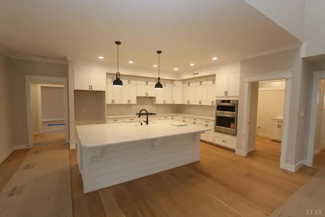 a large room with a lot of counter space and wooden floor