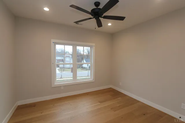 an empty room with a window and a fan