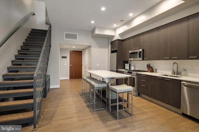 a kitchen with granite countertop lots of white cabinets and stainless steel appliances