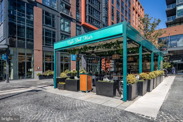 a view of a cafe with a table and chairs under an umbrella