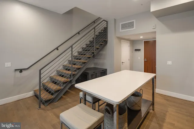 a dining hall with stainless steel appliances granite countertop a sink a stove a dining table and chairs