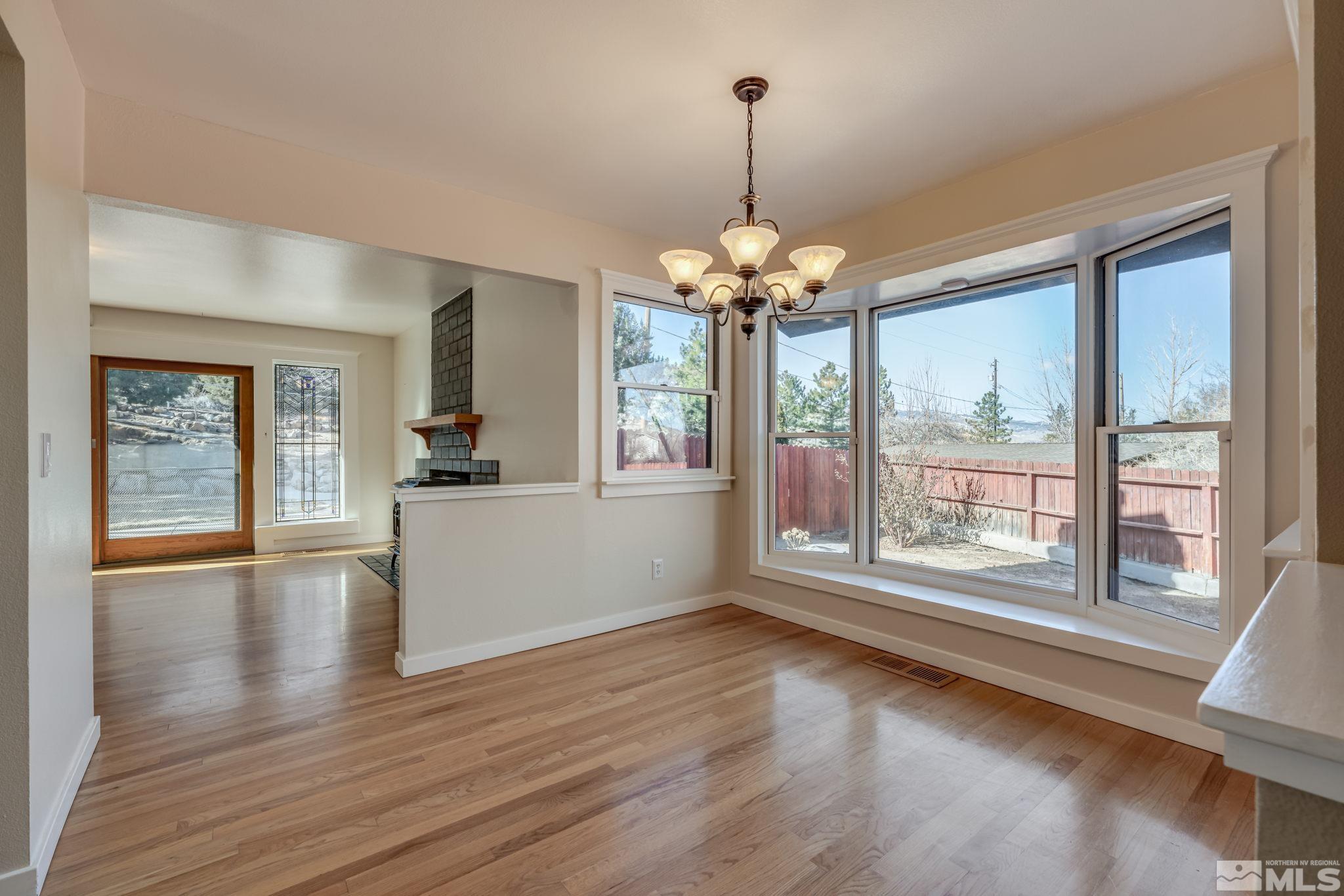 14185 Minnetonka Circle Reno, NV 89521 - Photo 7 of 32 a view of a room with wooden floor chandelier and windows
