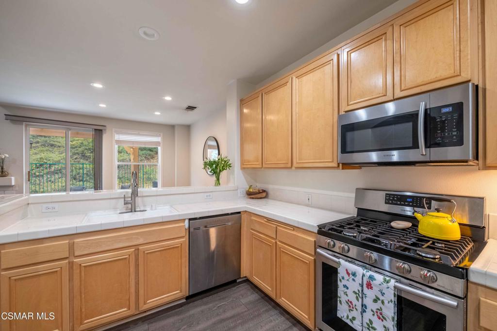 580 Fenwick Way, Unit C Simi Valley, CA 93065 - Photo 13 of 39 a kitchen with stainless steel appliances granite countertop a stove a sink and a microwave