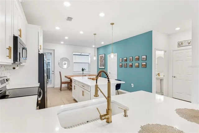 a living room with furniture a flat screen tv and a refrigerator