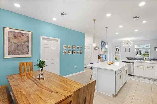 a room with stainless steel appliances kitchen island a table and chairs