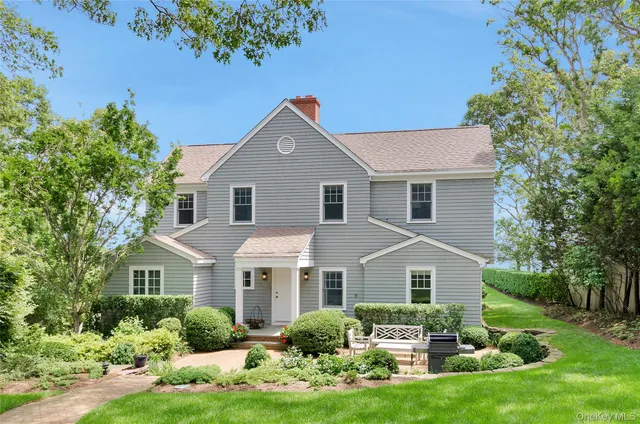 a front view of a house with a yard and potted plants