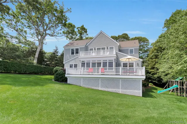 a view of a house with a big yard and large trees
