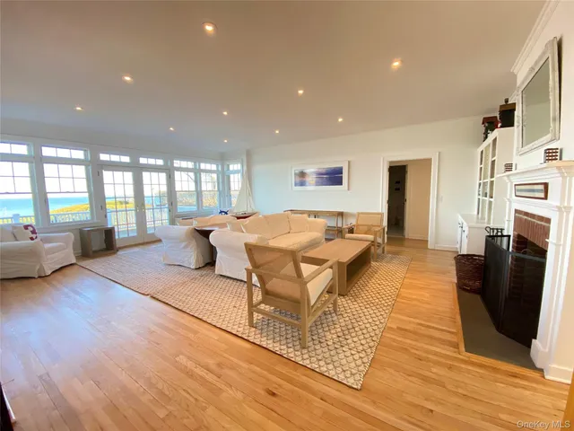 a living room with furniture a large window and wooden floor