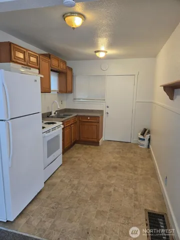 a kitchen with cabinets and white stainless steel appliances