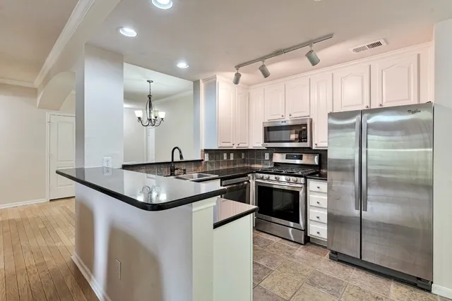 a kitchen with granite countertop a sink a stove and cabinets