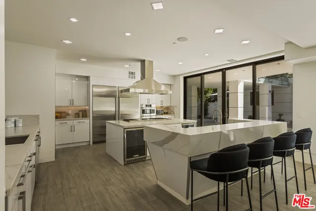 a large white kitchen with a table and chairs in it