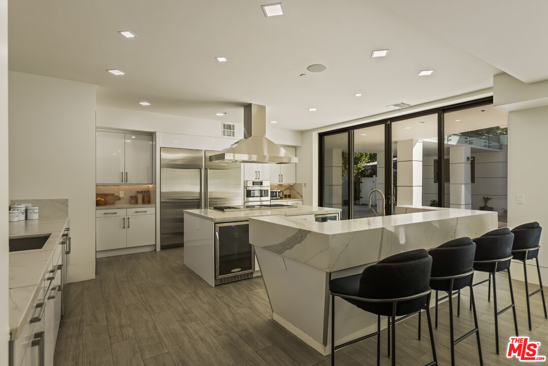 4230 Valley Meadow Road Encino, CA 91436 - Photo 12 of 44 a large white kitchen with a table and chairs in it