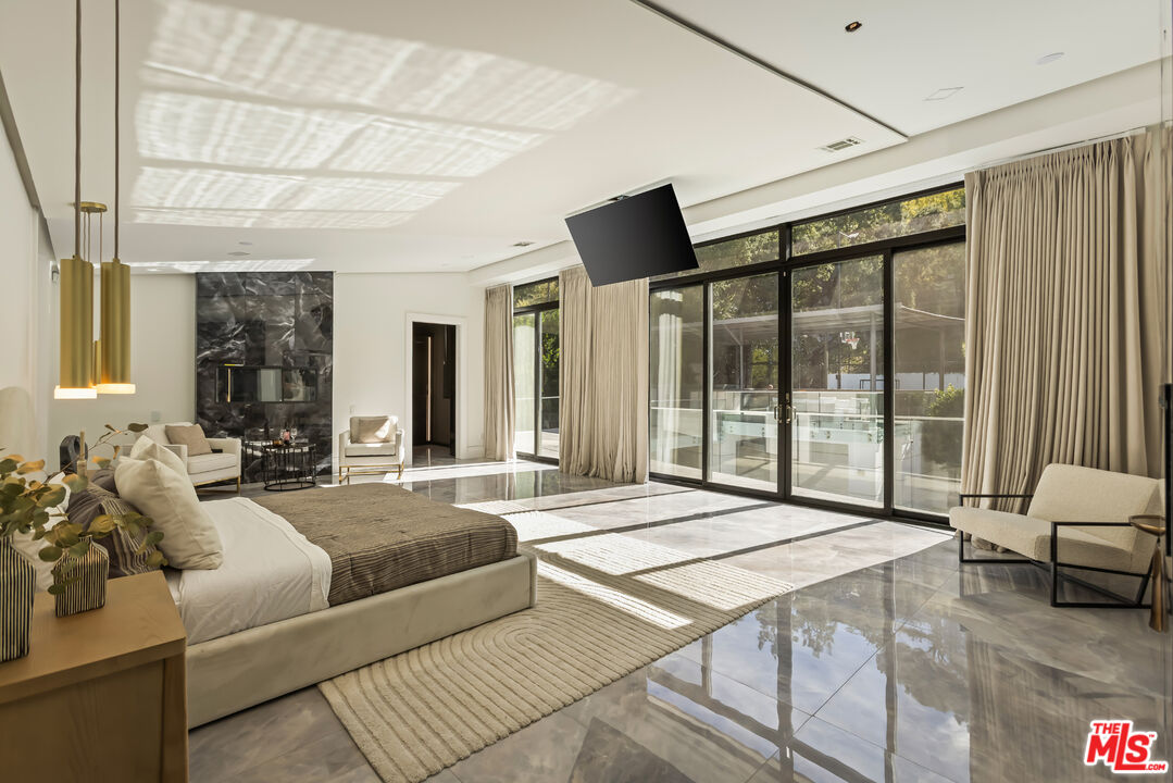 4230 Valley Meadow Road Encino, CA 91436 - Photo 16 of 44 a bedroom with a large bed and a large window