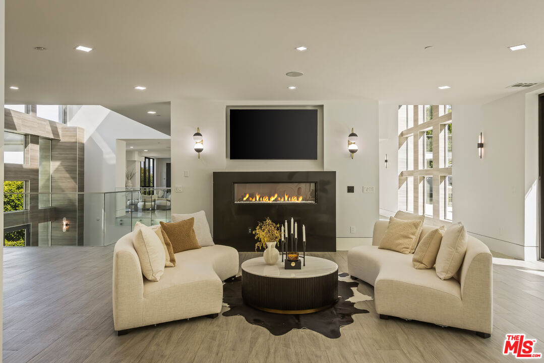 4230 Valley Meadow Road Encino, CA 91436 - Photo 24 of 44 a living room with furniture a fireplace and a flat screen tv