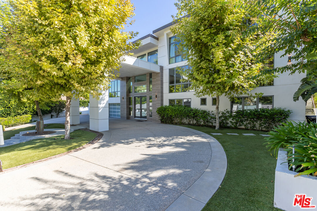 4230 Valley Meadow Road Encino, CA 91436 - Photo 3 of 44 a view of a white house with a small yard and large tree