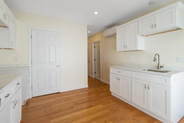 a kitchen with white cabinets and sink