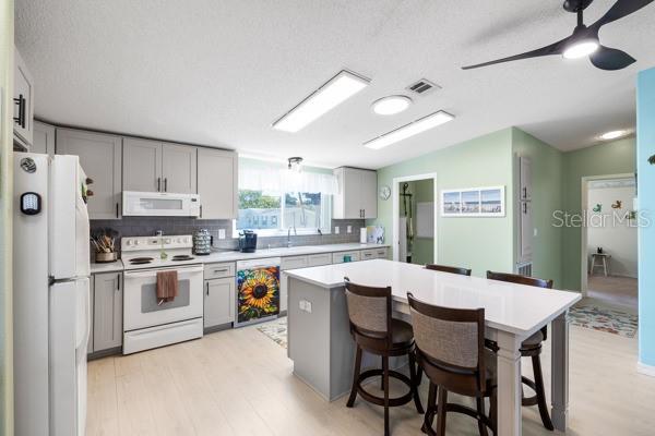 6333 Bear Trail Weeki Wachee, FL 34607 - Photo 14 of 52 a kitchen with a dining table chairs stainless steel appliances and cabinets