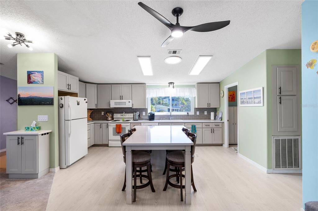 6333 Bear Trail Weeki Wachee, FL 34607 - Photo 4 of 52 a kitchen with stainless steel appliances a table chairs refrigerator and cabinets