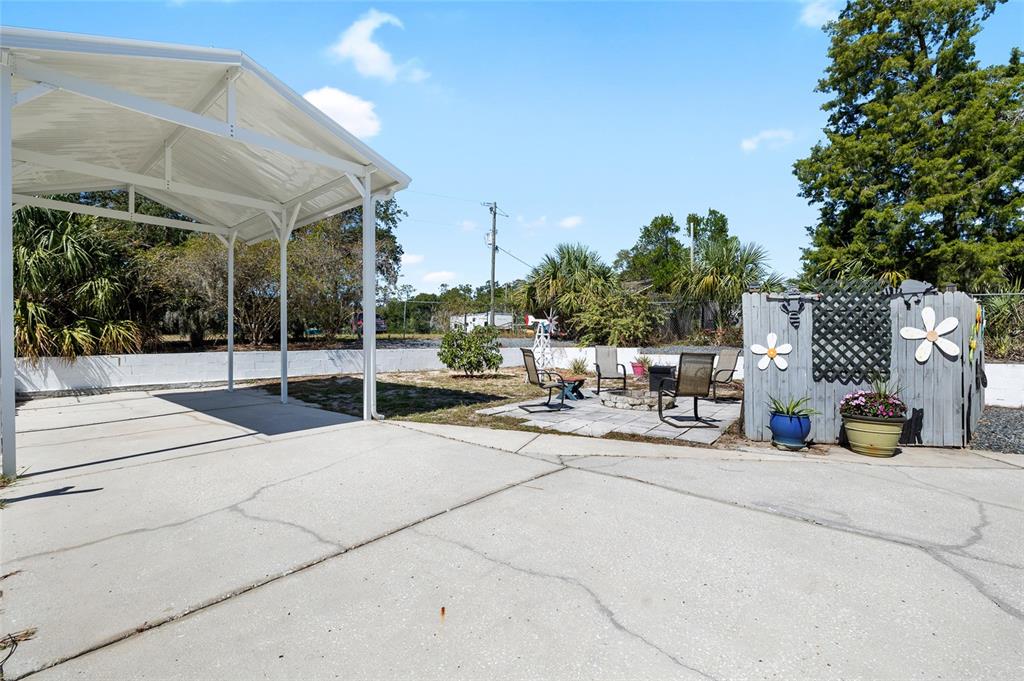 6333 Bear Trail Weeki Wachee, FL 34607 - Photo 42 of 52 a view of a patio with a table and chairs and potted plants