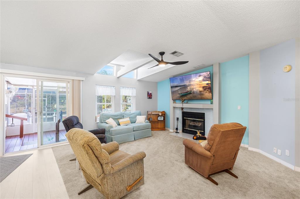 6333 Bear Trail Weeki Wachee, FL 34607 - Photo 10 of 52 a living room with furniture a fireplace and a flat screen tv