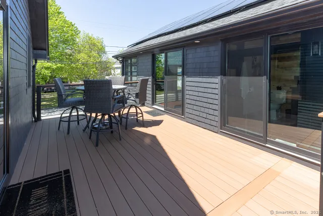 a patio with table and chairs and potted plants