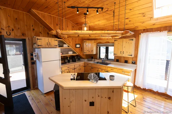 a kitchen with stainless steel appliances granite countertop a stove a sink dishwasher and a refrigerator with wooden floor