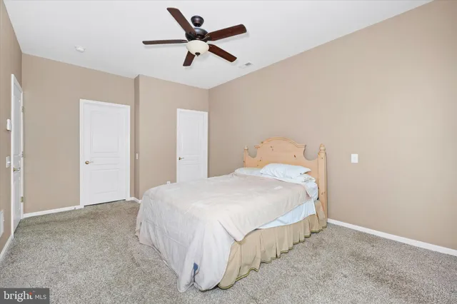 a spacious bedroom with a bed and a ceiling fan