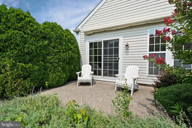 a white house with table and chairs in front of it