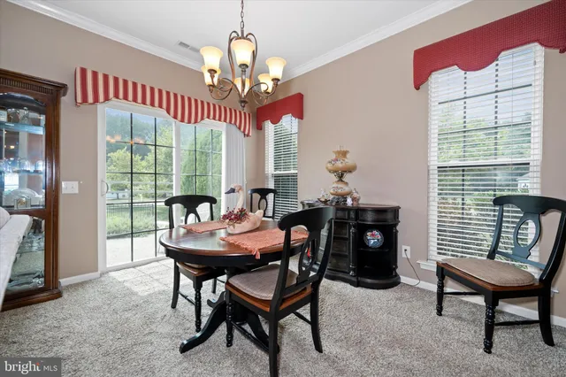 a dining room with furniture a chandelier and window