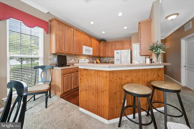 a kitchen with stainless steel appliances granite countertop table chairs sink and window