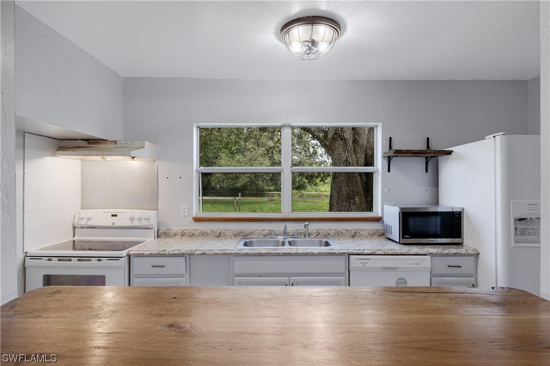 2701 Packinghouse Road Alva, FL 33920 - Photo 15 of 33 a living room with stainless steel appliances kitchen island granite countertop furniture and a flat screen tv
