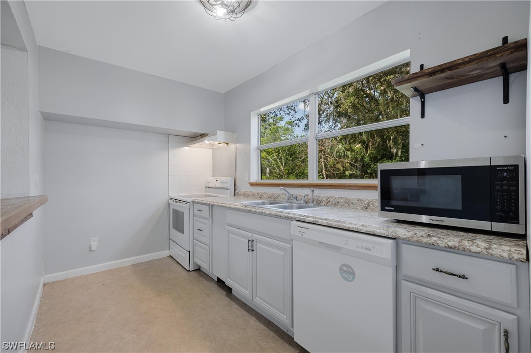 2701 Packinghouse Road Alva, FL 33920 - Photo 17 of 33 a kitchen with stainless steel appliances white cabinets and a sink