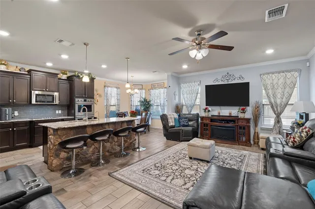 a living room with furniture kitchen view and a flat screen tv
